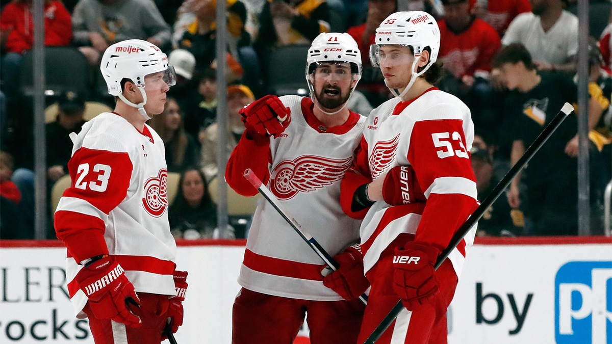 Detroit Red Wings left wing Lucas Raymond (23) and center Dylan Larkin (71) and defenseman Moritz Seider (53) talk before the overtime period against the Pittsburgh Penguins at PPG Paints Arena.