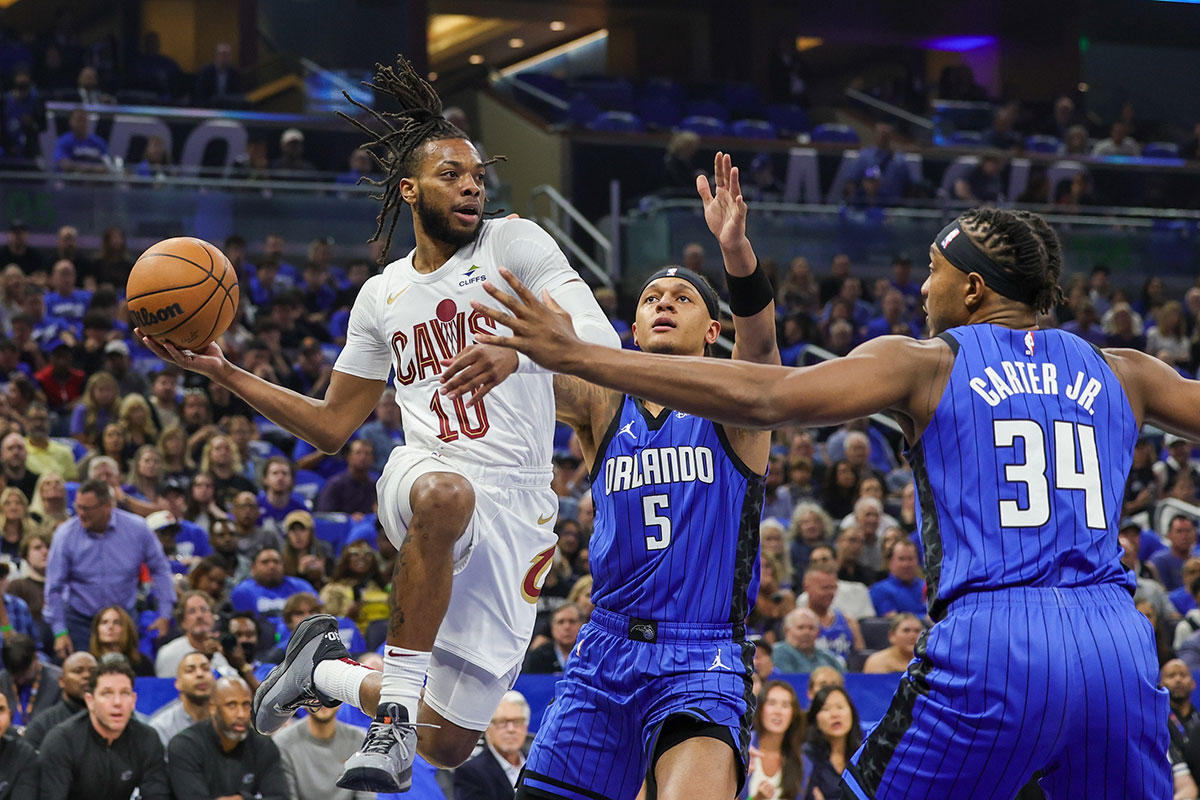 Cleveland Cavaliers guard Darius Garland (10) passes the ball between Orlando Magic forward Paolo Banchero (5) and center Wendell Carter Jr. (34) during the first quarter of game six of the first round for the 2024 NBA playoffs at Kia Center.