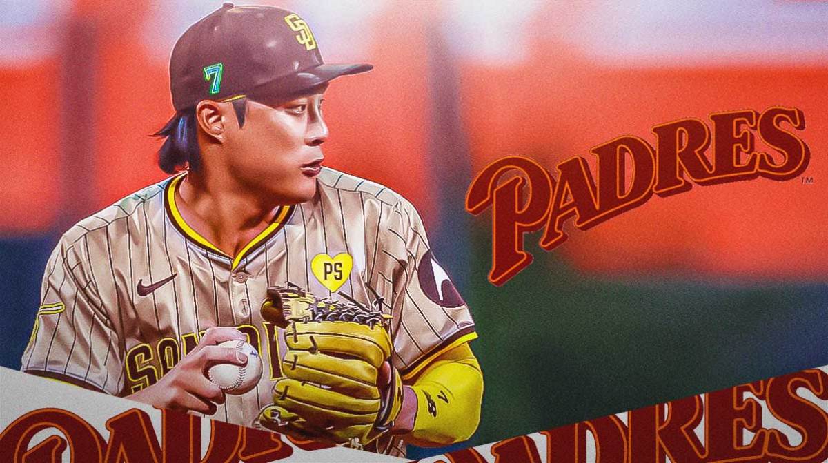 Padres' Ha-Seong Jim looks at injury reports during practice, NL West banner in background