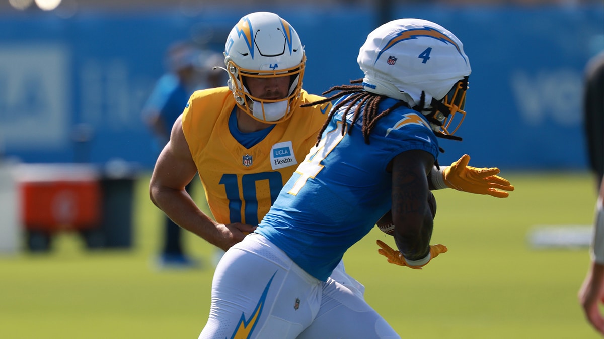 Los Angeles Chargers quarterback Justin Herbert (10) hands a ball off to running back Gus Edwards (4) during the first day of training camp at The Bolt. 