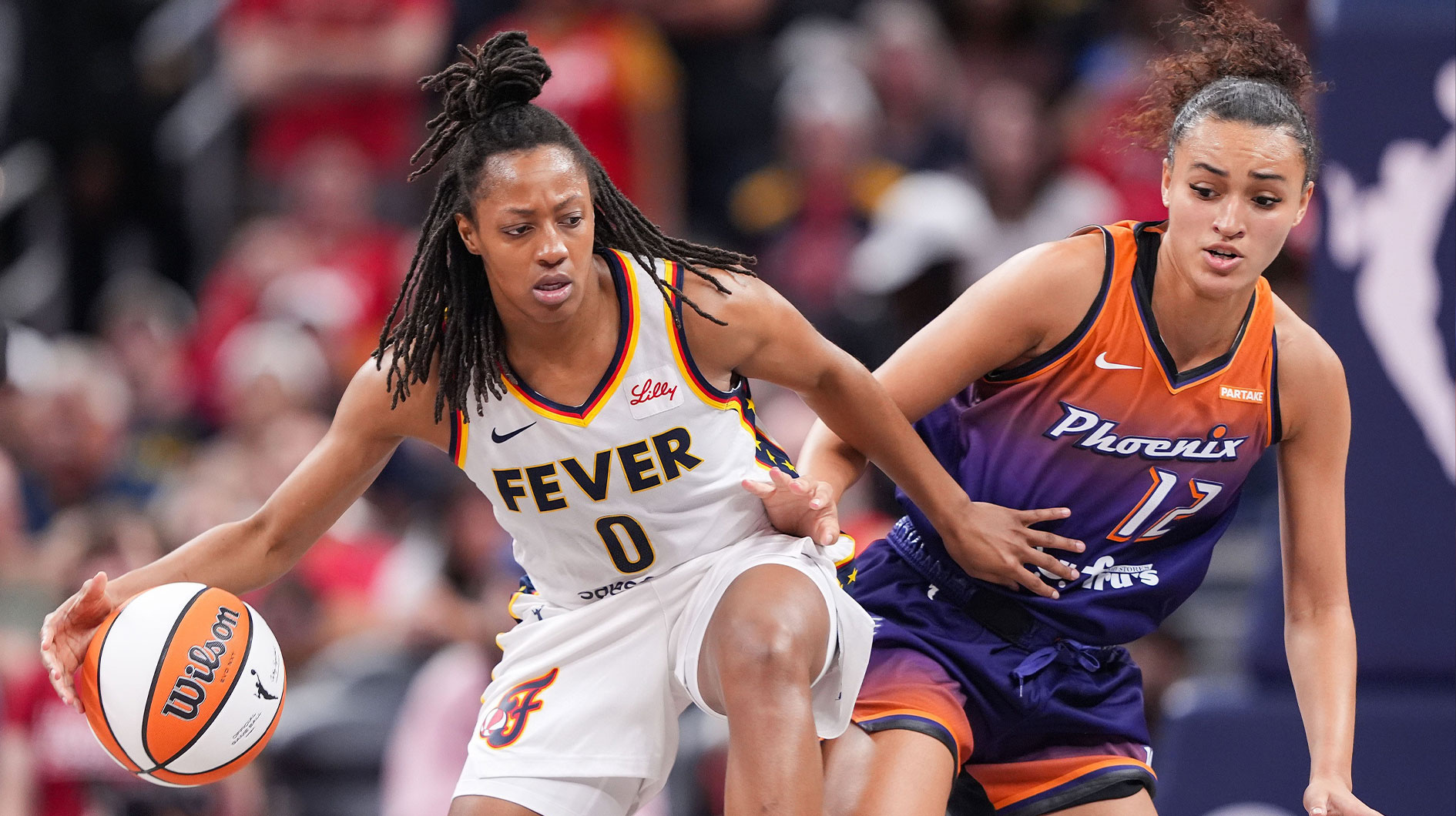 Indiana Fever defender Kelsey Mitchell (0) charges up the field against Phoenix Mercury defender Celeste Taylor (12) during the game at Gainbridge Fieldhouse in Indianapolis on Friday, July 12, 2024. The Indiana Fever defeated the Phoenix Mercury 95-86.