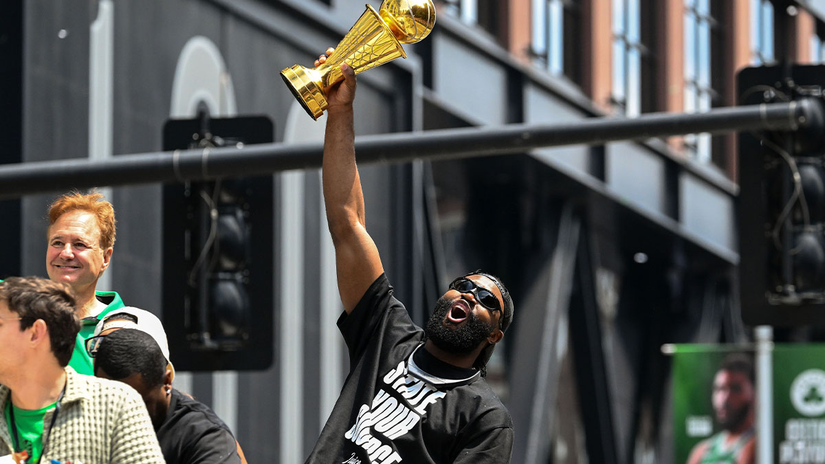 Jaylen Brown (7) holds up the Larry O'Brien Championship Trophy