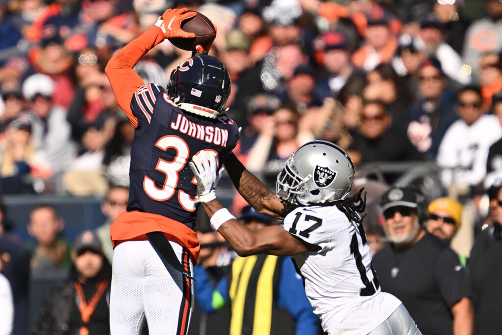 Chicago Bears defensive back Jaylon Johnson (33) steps in front of Las Vegas Raiders wide receiver Davante Adams (17) to intercept a pass before returning the ball for a touchdown in the fourth quarter at Soldier Field.