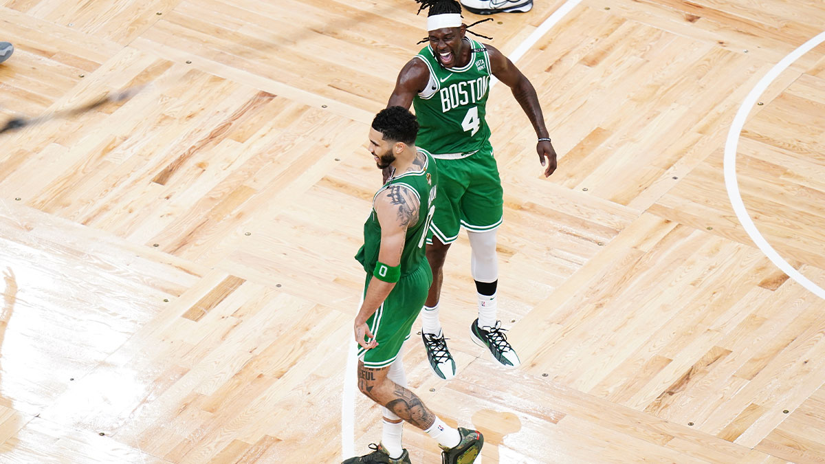Boston Celtics forward Jayson Tatum (0) reacts with guard Jrue Holiday (4) in the fourth quarter against the Dallas Mavericks during game five of the 2024 NBA Finals at TD Garden.