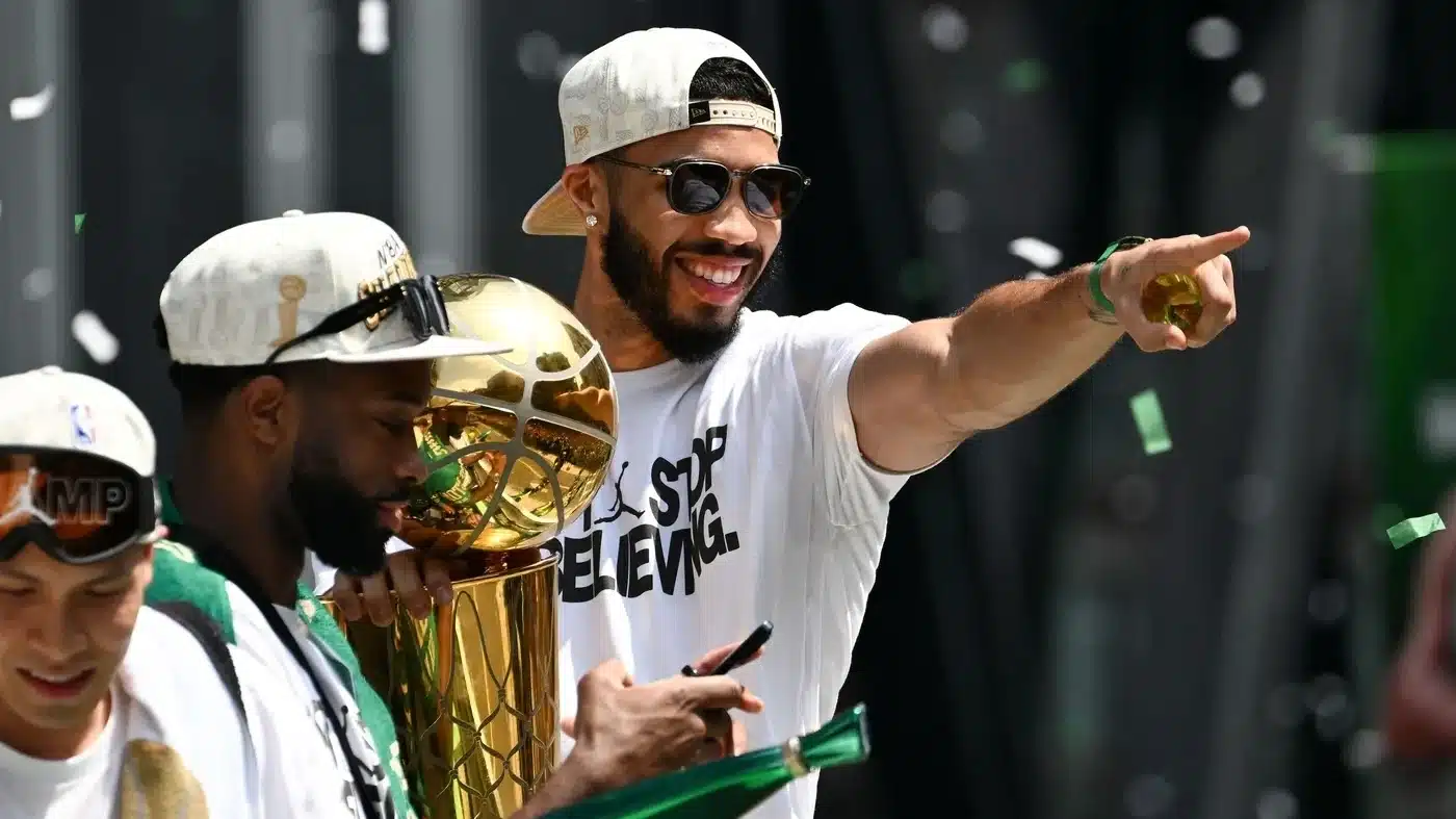 Boston Celtics forward Jayson Tatum (0) points to the crowd with the Larry O'Brien Championship Trophy during the 2024 NBA Championship parade in Boston.