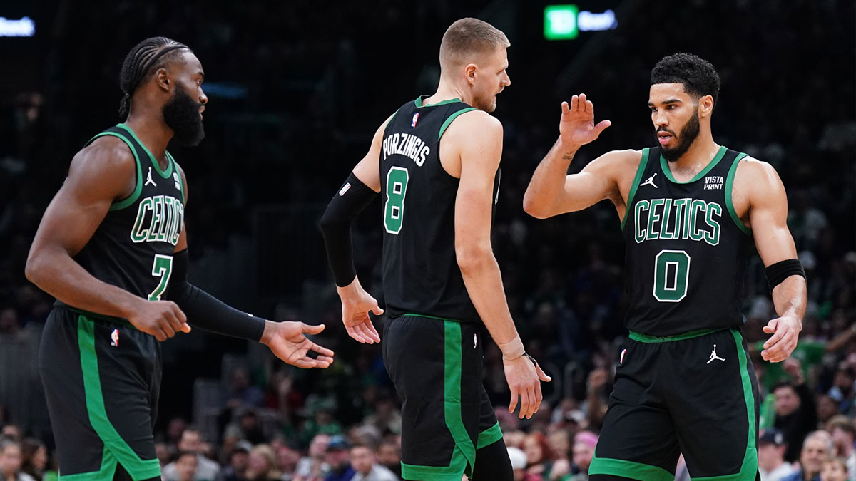 Boston Celtics forward Jayson Tatum (0), center Kristaps Porzingis (8) and guard Jaylen Brown (7) react after a play against the New York Knicks in the second quarter at TD Garden.