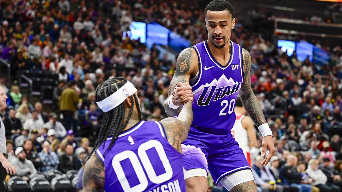 Utah Jazz forward/center John Collins (20) helps guard Jordan Clarkson (00) off the ground against the Washington Wizards during the second half at the Delta Center. 