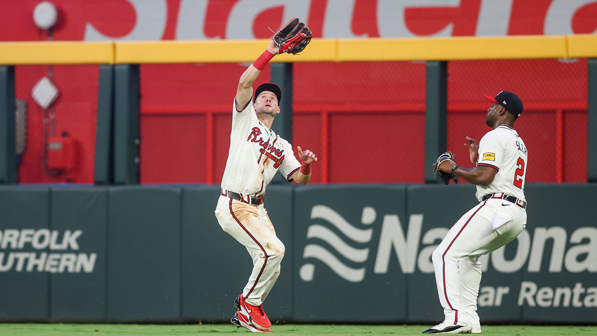 Atlanta Braves center fielder Jarred Kelenic (24) catches a fly ball as right fielder Jorge Soler (2) looks on against the Miami Marlins in the fifth inning at Truist Park.