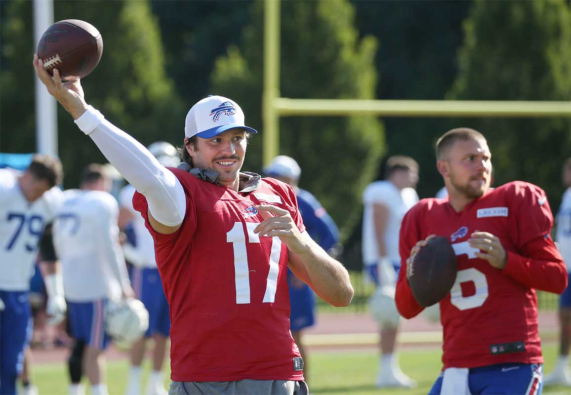 Bills quarterbacks Josh Allen and Shane Buechele warm up on the sideline.