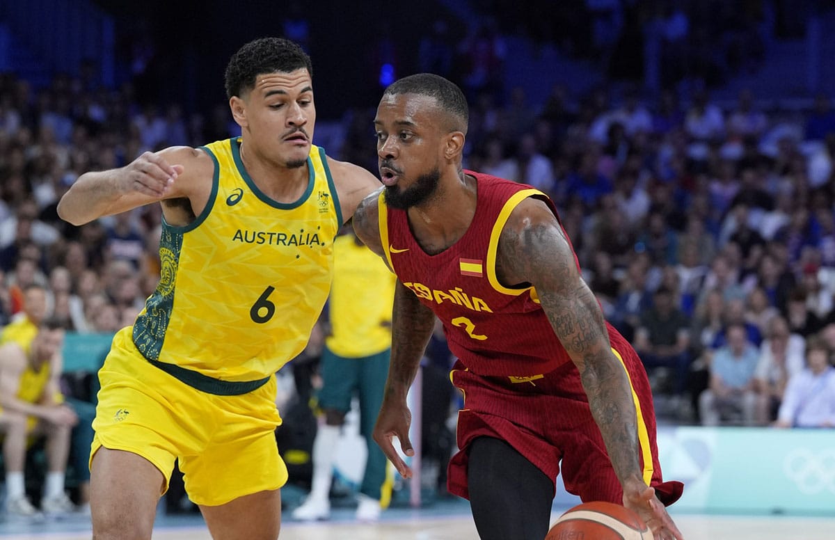 Spain guard Lorenzo Brown (2) drives past Australia small forward Josh Green (6) in men's Group A play during the Paris 2024 Olympic Summer Games at Stade Pierre-Mauroy.