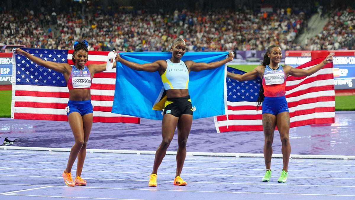 Gold medalist Julien Alfred (LCA), silver medalist Sha'carri Richardson (USA) and bronze medalist Melissa Jefferson (USA) celebrate after the women's 100m final during the Paris 2024 Olympic Summer Games at Stade de France. 