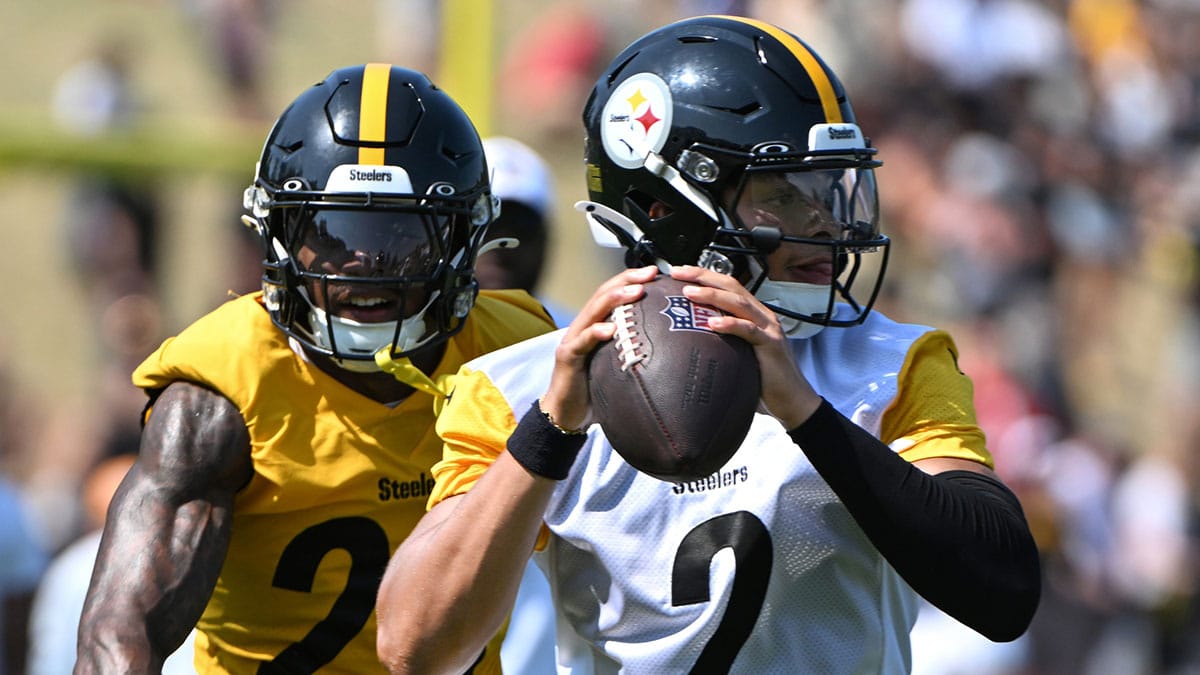 Pittsburgh Steelers quarterback Justin Fields (2) is pressured by safety DeShon Elliott (25) during training camp at Saint Vincent College.