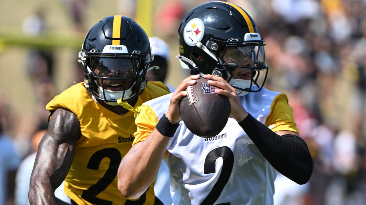 Pittsburgh Steelers quarterback Justin Fields (2) is pressured by safety DeShon Elliott (25) during training camp at Saint Vincent College.