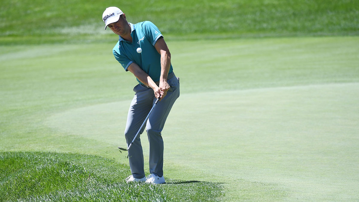 Justin Thomas hits a chip shot on the ninth hole during the first round of the BMW Championship golf tournament at Castle Pines Golf Club.