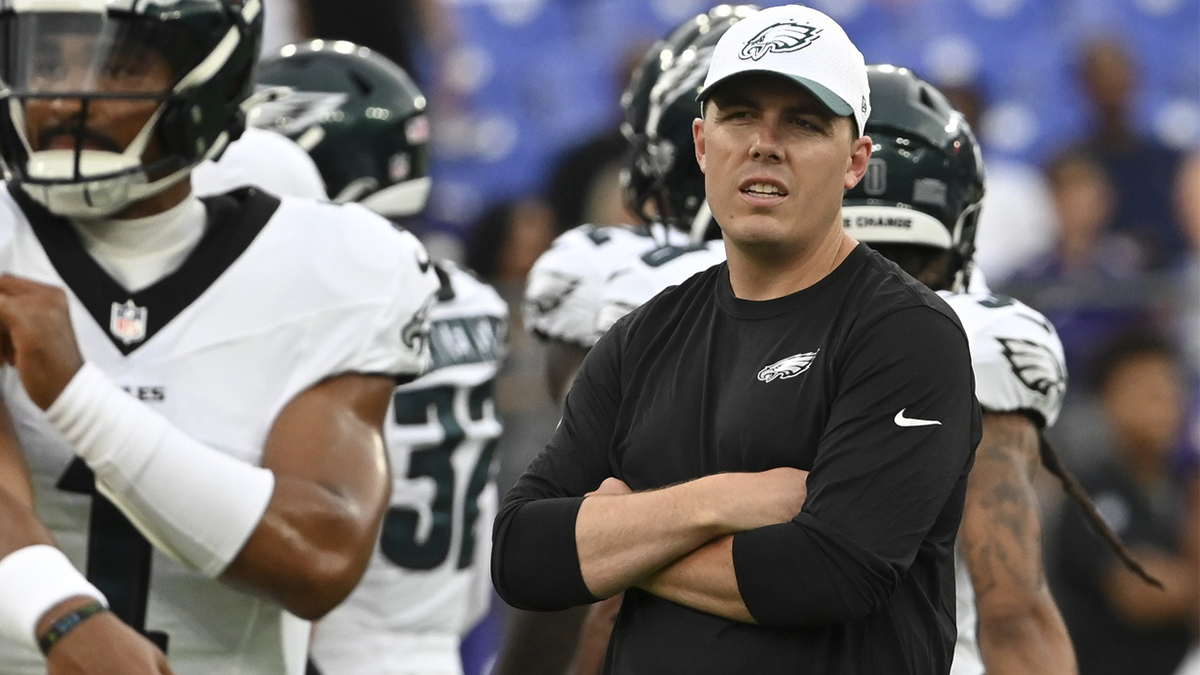 Philadelphia Eagles offensive coordinator Kellen Moore looks on as quarterback Jalen Hurts (1) throws before a preseason game against the Baltimore Ravens at M&T Bank Stadium.