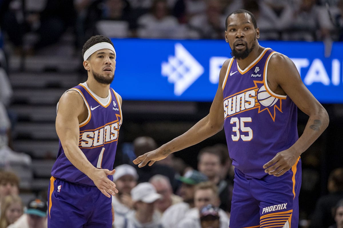     Phoenix Suns guard Devin Booker (1) shakes hands with forward Kevin Durant (35) during the first half of game one of the first round of the 2024 NBA Playoffs against the Minnesota Timberwolves at Target Center. 