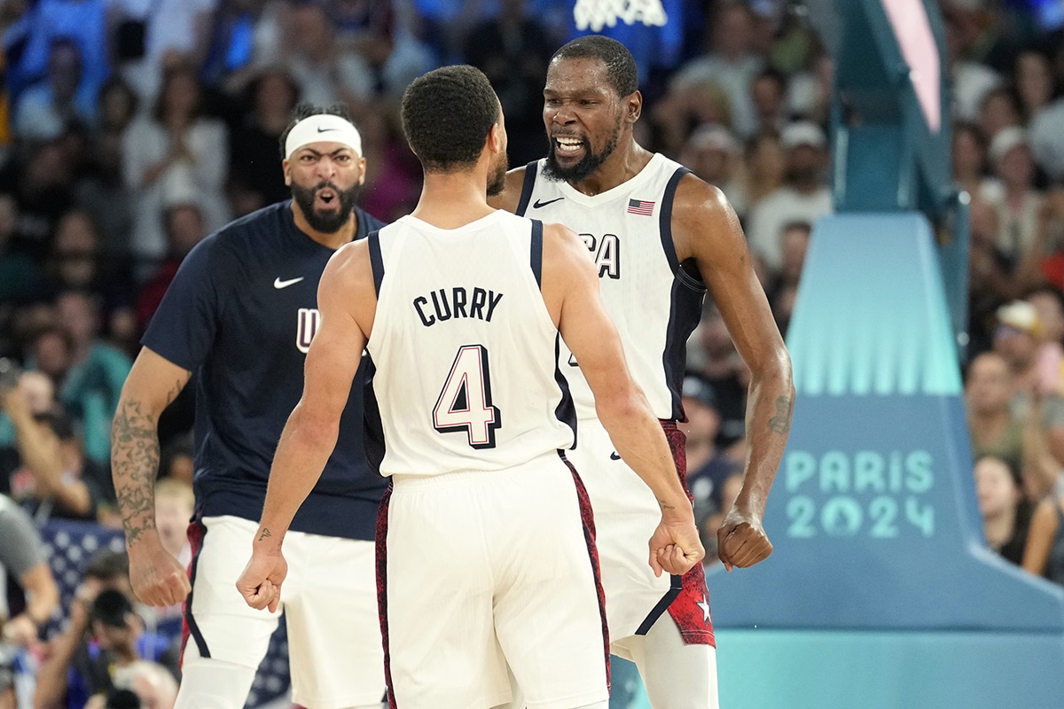 United States centre Anthony Davis (left), guard Kevin Durant (right) and shooting guard Stephen Curry (4) celebrate during the second half against Serbia in a men's basketball semifinal game during the Paris 2024 Olympic Summer Games at Accor Arena.