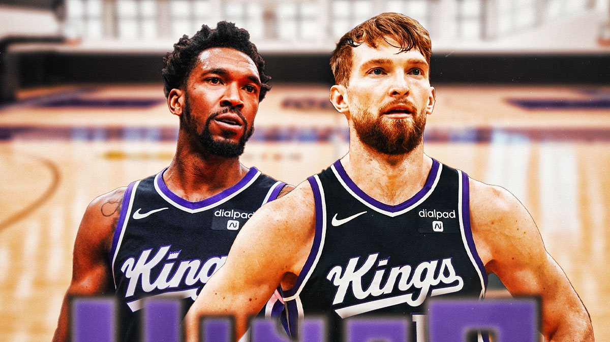 Kings star Domantas Sabonis looking serious on the Kings' floor next to Kings guard Molik Monk