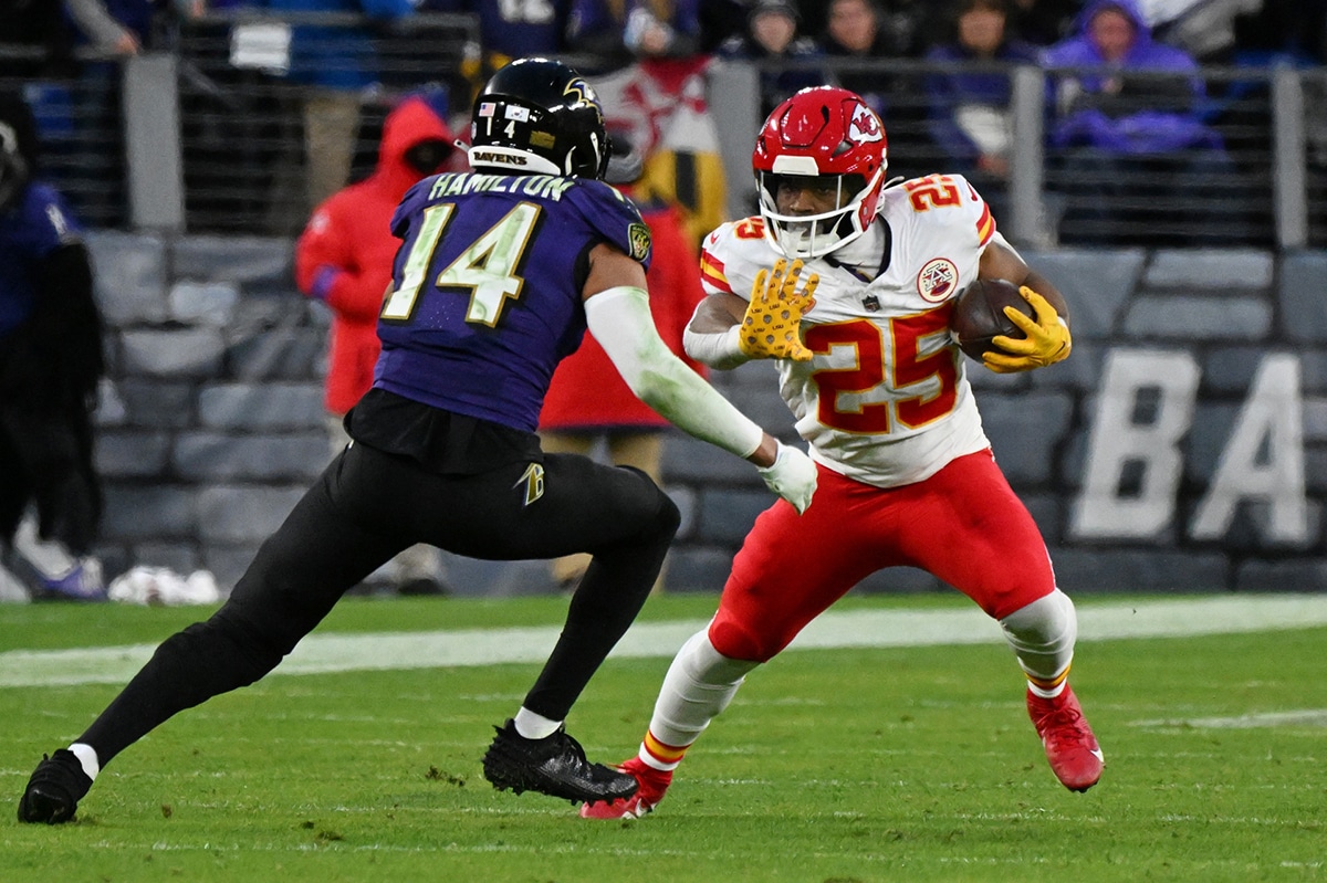 Kansas City Chiefs running back Clyde Edwards-Helaire (25) runs with the ball against Baltimore Ravens safety Kyle Hamilton (14) during the second half in the AFC Championship football game at M&T Bank Stadium.