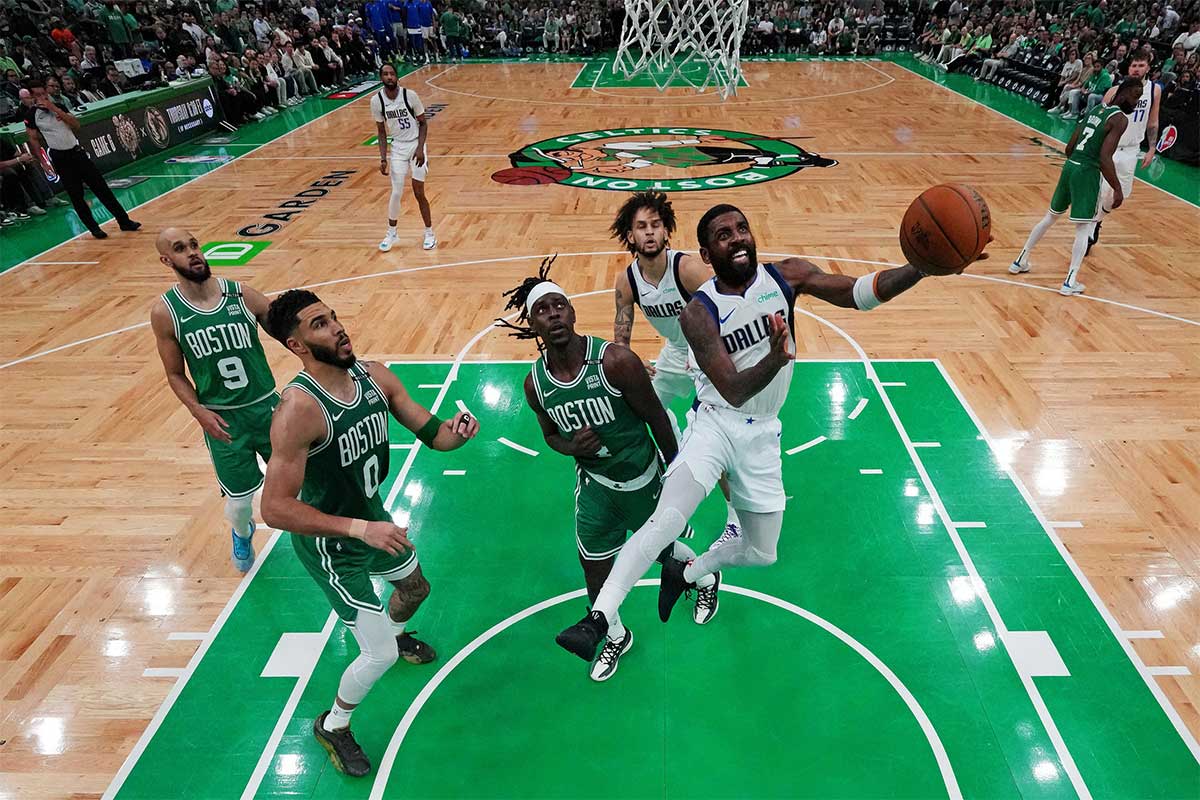 Dallas Mavericks guard Kyrie Irving (11) shoots the ball against Boston Celtics guard Jrue Holiday (4) in game five of the 2024 NBA Finals at TD Garden.