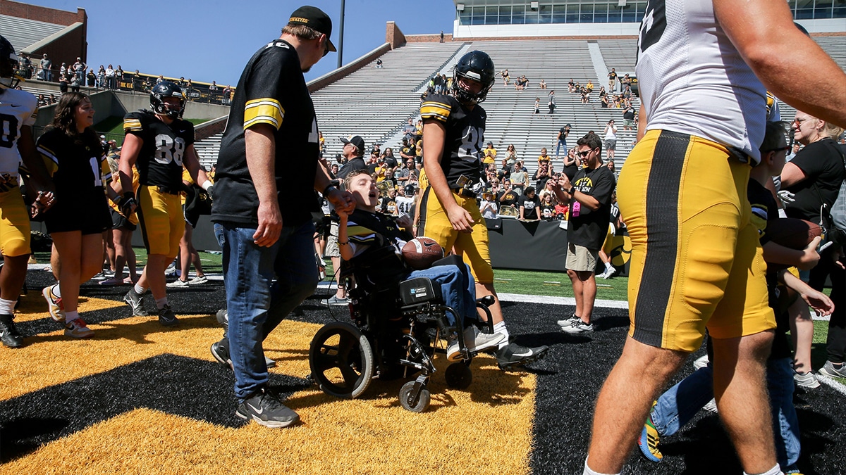 Iowa Luke Lachey (85) walks out with one of the Kid Captains during Kids Day at Kinnick Saturday, Aug. 10, 2024 at Kinnick Stadium in Iowa City, Iowa.