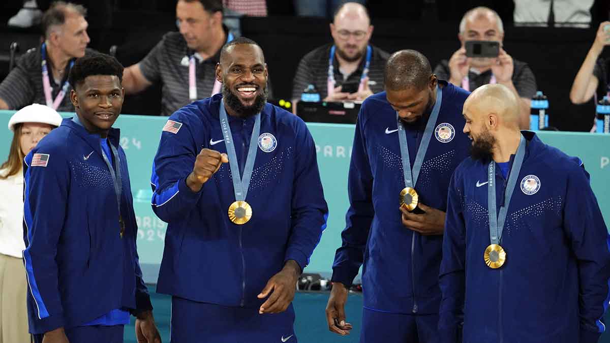 United States guard Anthony Edwards (5) and guard LeBron James (6) and guard Kevin Durant (7) and guard Derrick White (8) celebrate with their gold medals on the podium after defeating France in the men's basketball gold medal game during the Paris 2024 Olympic Summer Games at Accor Arena.