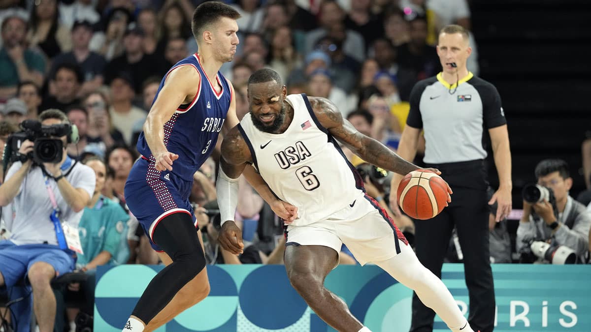 United States guard LeBron James (6) drives to the basket while defended by Serbia centre Filip Petrusev (3) during the first half in a men's basketball semifinal game during the Paris 2024 Olympic Summer Games at Accor Arena