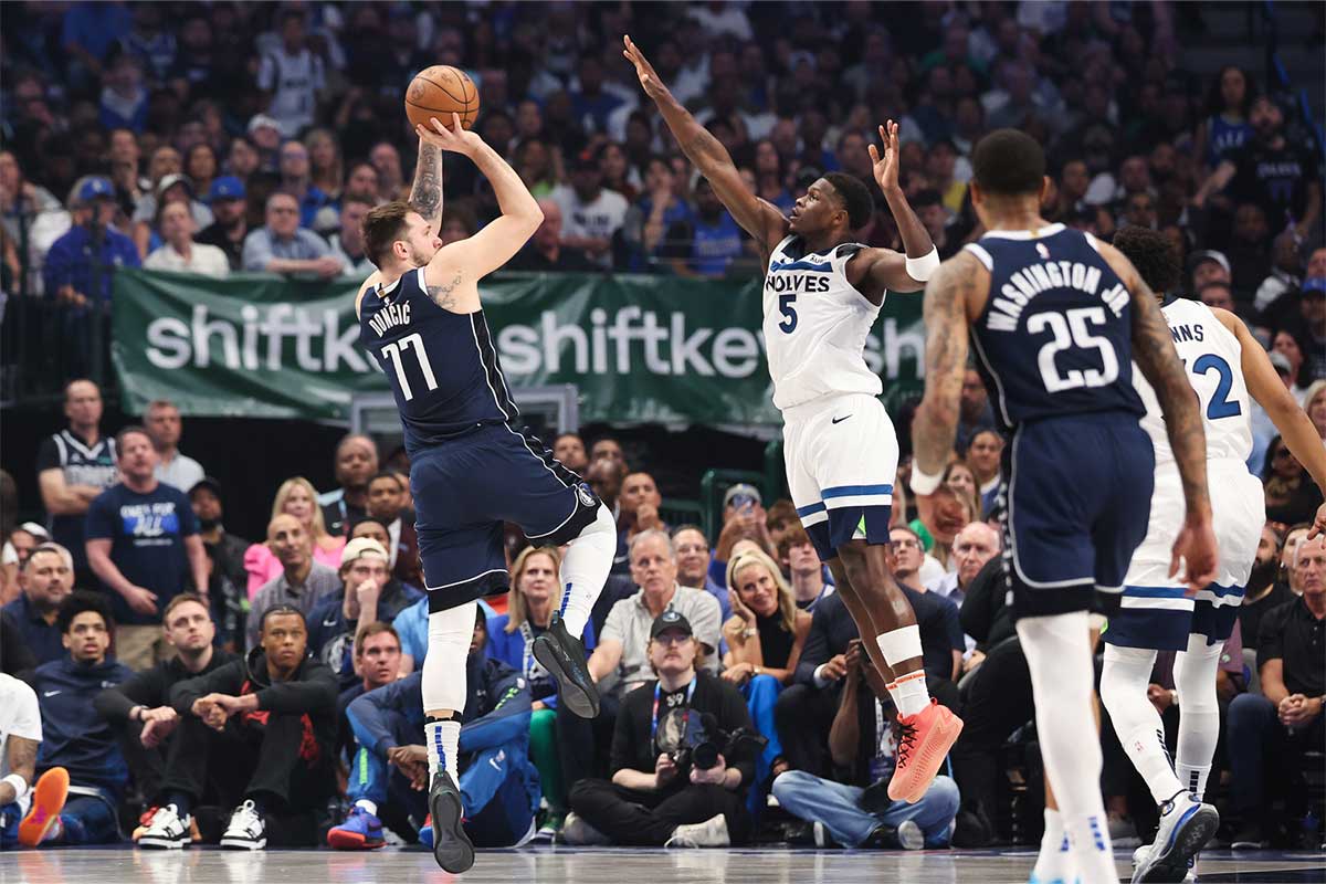 Dallas Mavericks guard Luka Doncic (77) shoots against Minnesota Timberwolves guard Anthony Edwards (5) during the first quarter of game four of the western conference finals for the 2024 NBA playoffs at American Airlines Center.