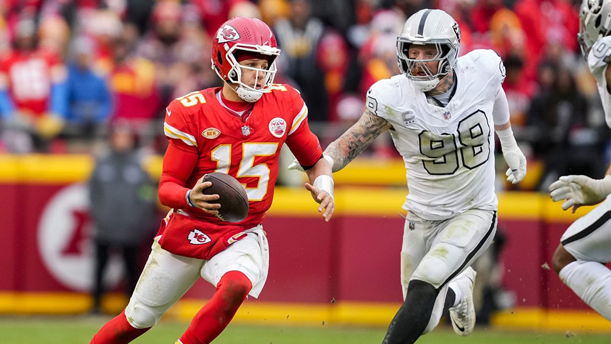 Kansas City Chiefs quarterback Patrick Mahomes (15) scrambles against Las Vegas Raiders defensive end Maxx Crosby (98) during the second half at GEHA Field at Arrowhead Stadium.