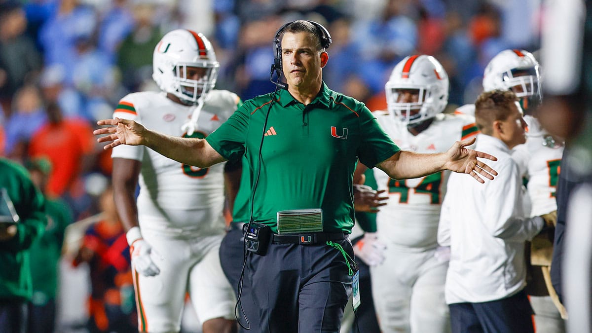 Miami Hurricanes head coach Mario Cristobal stands on the field during a timeout as the Hurricanes play against the North Carolina Tar Heels in the second half at Kenan Memorial Stadium.