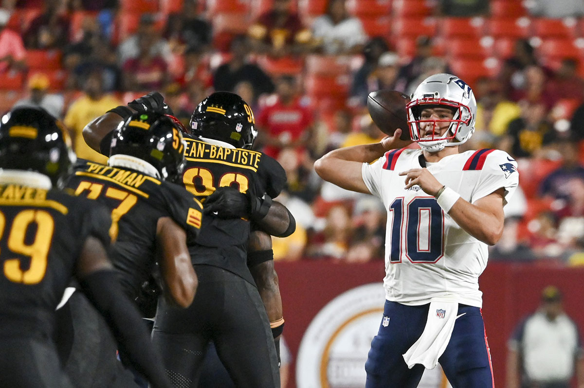 Landover, Maryland, USA; New England Patriots quarterback Drake Maye (10) throws with his back foot as the Washington Commanders defense applies pressure during the first half at Commanders Field.