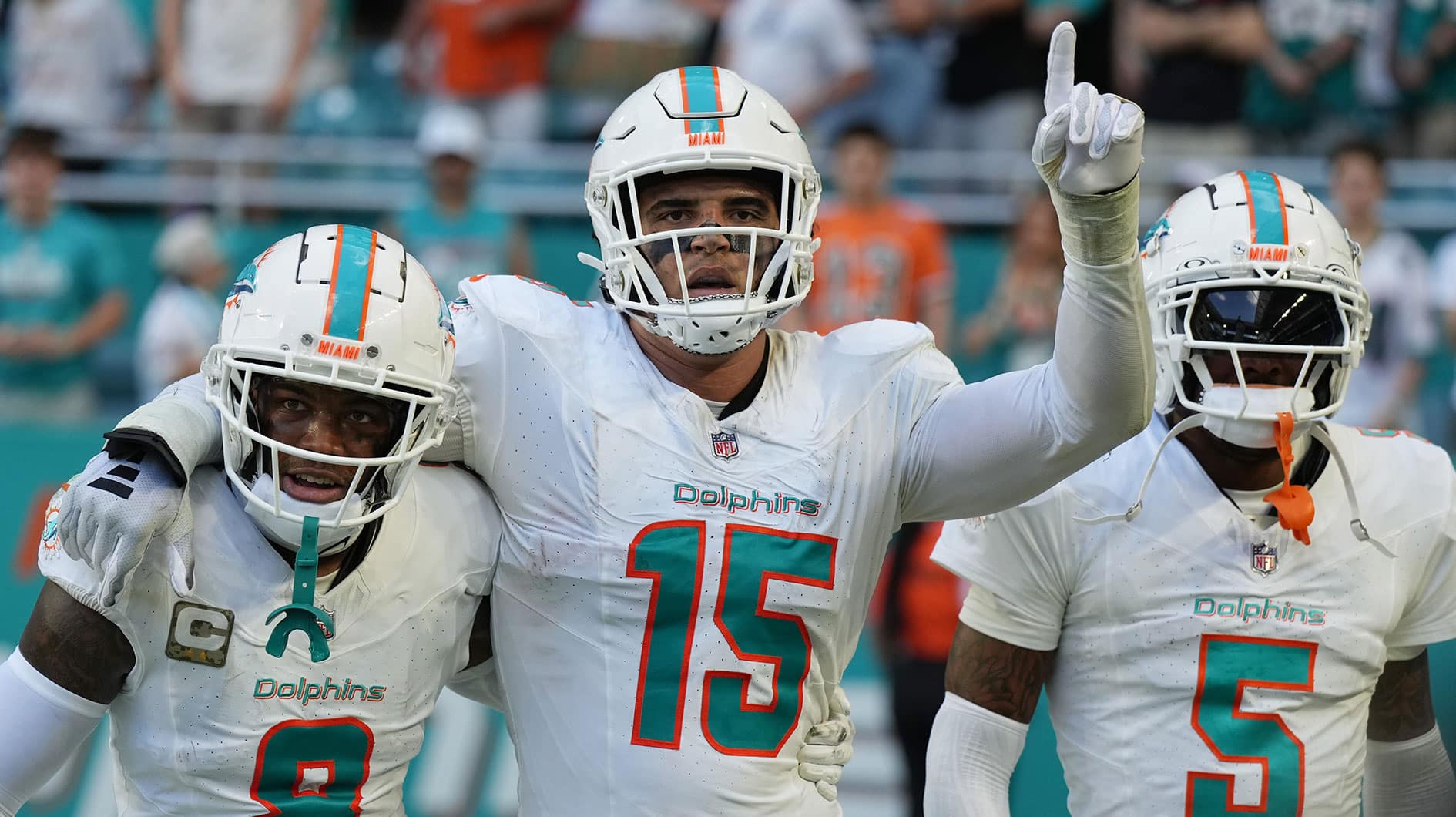 Miami Dolphins linebacker Jaelan Phillips (15) celebrates an interception during the second half of an NFL game against the Las Vegas Raiders with teammates safety Jevon Holland (8) and cornerback Jalen Ramsey (5) at Hard Rock Stadium.