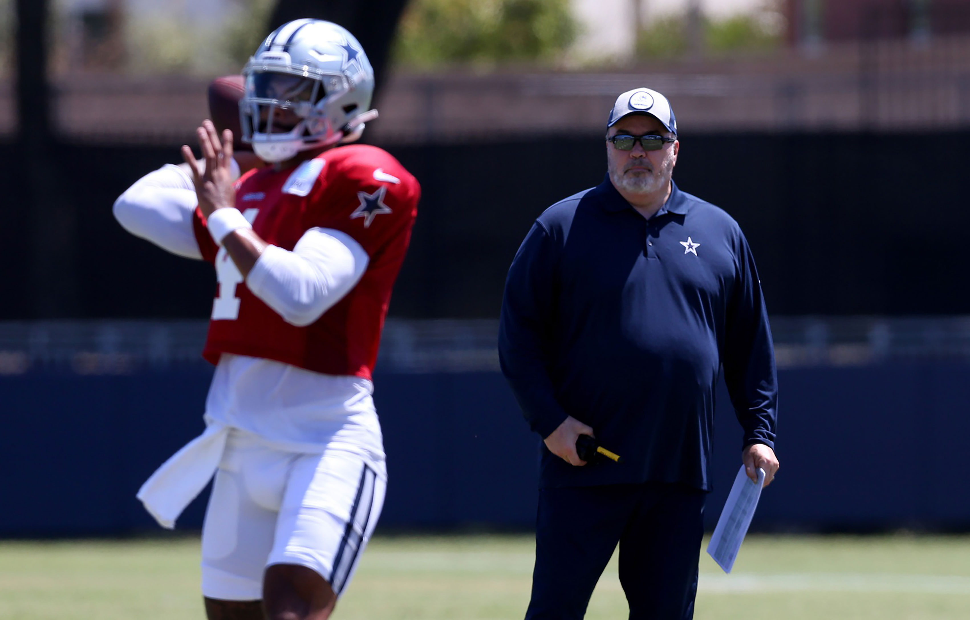 Dallas Cowboys head coach Mike McCarthy watches quarterback Dak Prescott (4) during training camp at the River Ridge Playing Fields in Oxnard, California.