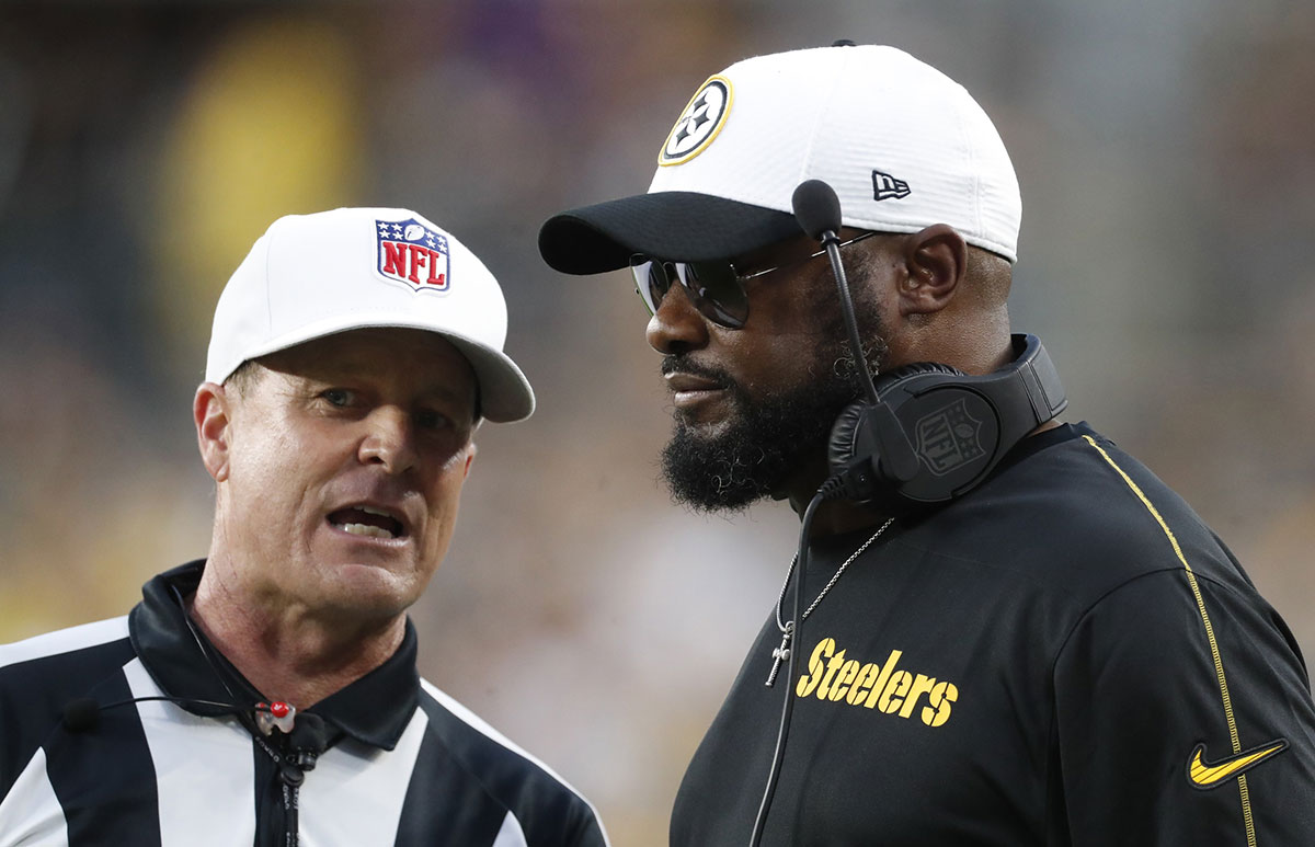 Pittsburgh Steelers head coach Mike Tomlin (right) listens to referee Shawn Hochuli (83) against the Buffalo Bills during the second quarter at Acrisure Stadium.