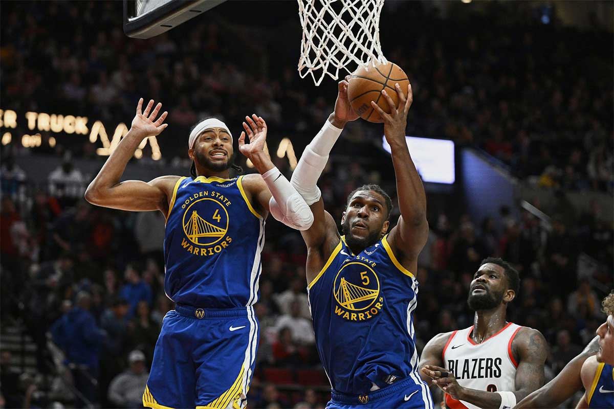 Golden State Warriors forward Kevon Looney (5) grabs a rebound during the second half with guard Moses Moody (4) against Portland Trail Blazers center Deandre Ayton (2) at Moda Center.