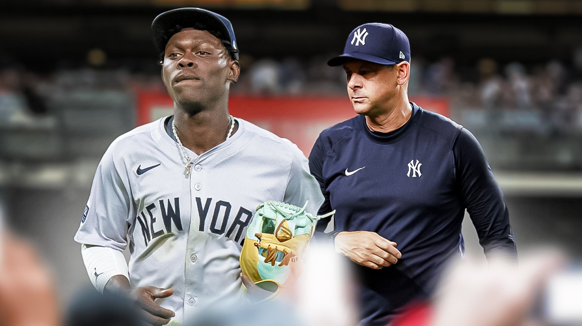 Yankees Jazz Chisholm Jr. limping off the baseball field with Yankees manager Aaron Boone watching