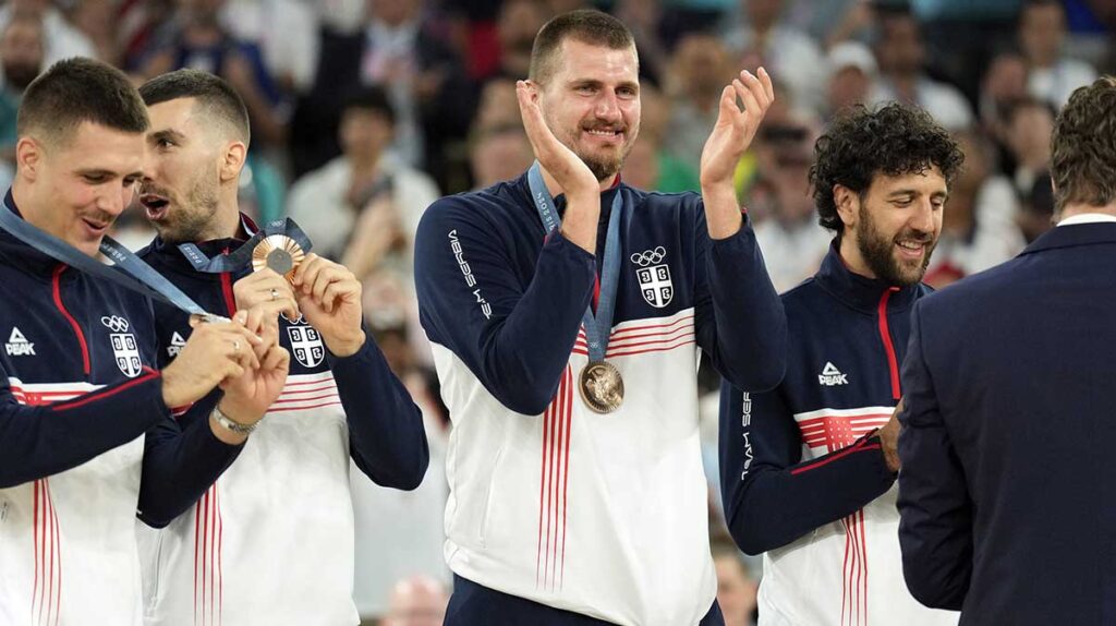 Serbia power forward Nikola Jokic (15) celebrates on the podium with teammates after winning the bronze medal in men's basketball during the Paris 2024 Olympic Summer Games at Accor Arena.