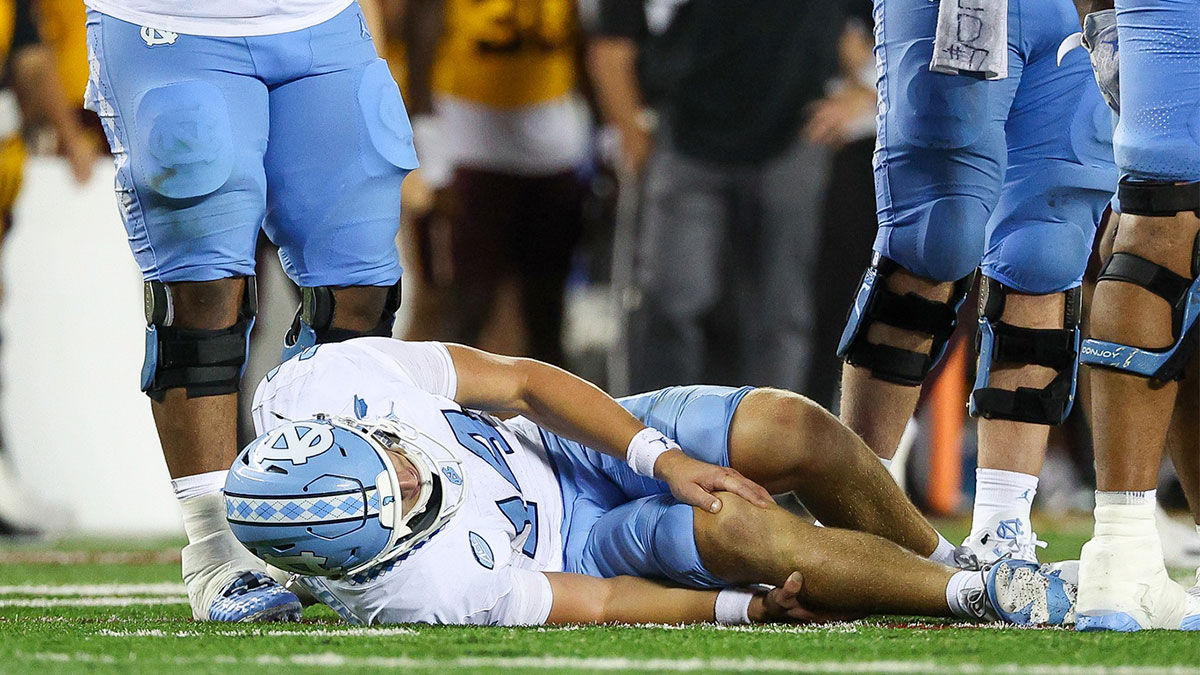 North Carolina Tar Heels quarterback Max Johnson (14) grabs his knee after being tackled during the second half against the Minnesota Golden Gophers at Huntington Bank Stadium.