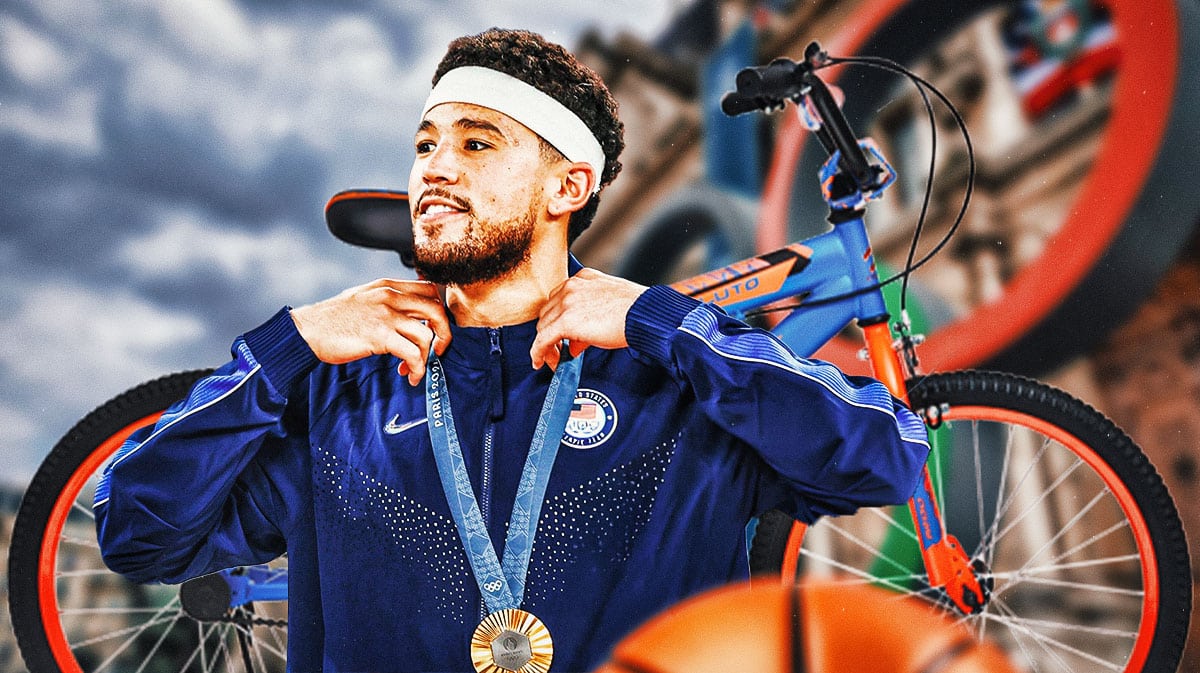 Devin Booker in a Team USA jersey with a gold medal around his neck, and bicycle next to him.