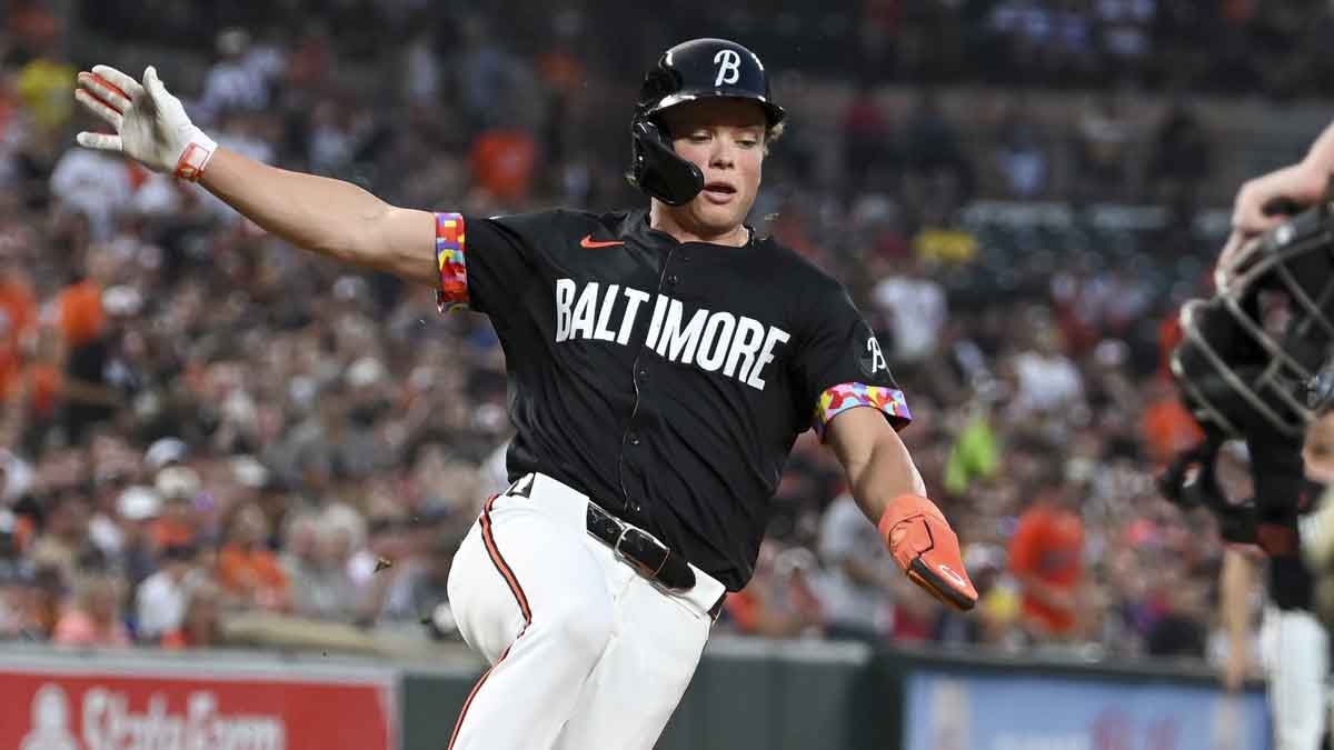 Jackson Holliday (7), second baseman of the Baltimore Orioles, slides and scores after an RBI single by third baseman Ramon Urias (not pictured) against the Boston Red Sox at Oriole Park at Camden Yards.