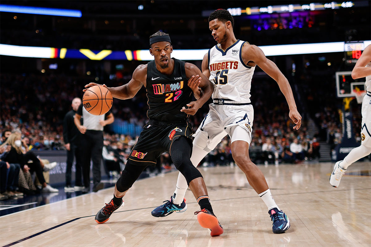 Miami Heat forward Jimmy Butler (22) controls the ball as Denver Nuggets guard P.J. Dozier (35) guards in the third quarter at Ball Arena.