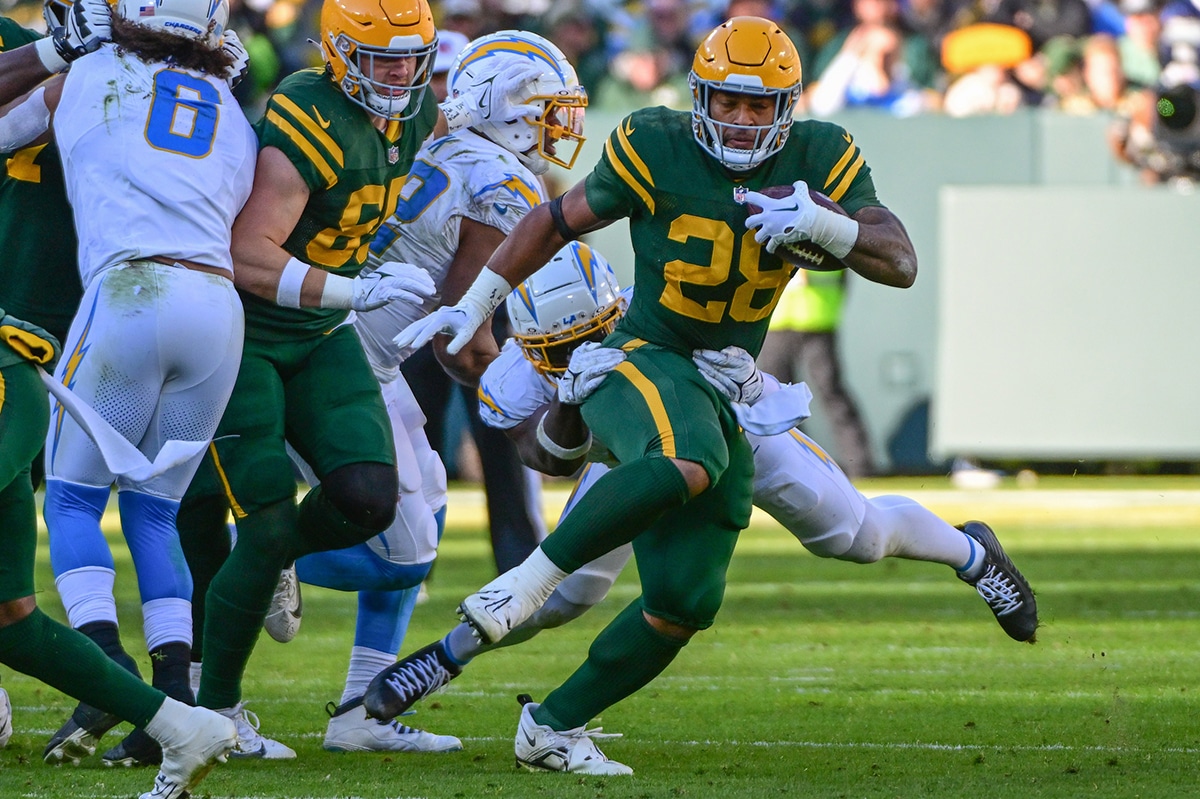 Green Bay Packers running back AJ Dillion (28) is tackled by Los Angeles Chargers linebacker Kenneth Murray (9) in the third quarter at Lambeau Field. Mandatory Credit: Benny Sieu-USA TODAY Sports