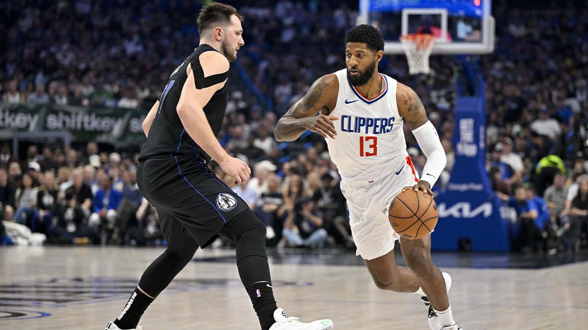 LA Clippers forward Paul George (13) moves the ball past Dallas Mavericks guard Luka Doncic (77) during the first quarter during game six of the first round for the 2024 NBA playoffs at American Airlines Center.