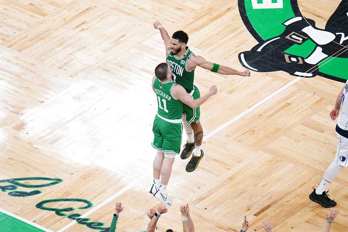 Boston Celtics guard Payton Pritchard (11) celebrates with forward Jayson Tatum (0) after a three point shot in the second quarter against the Dallas Mavericks during game five of the 2024 NBA Finals at TD Garden. 