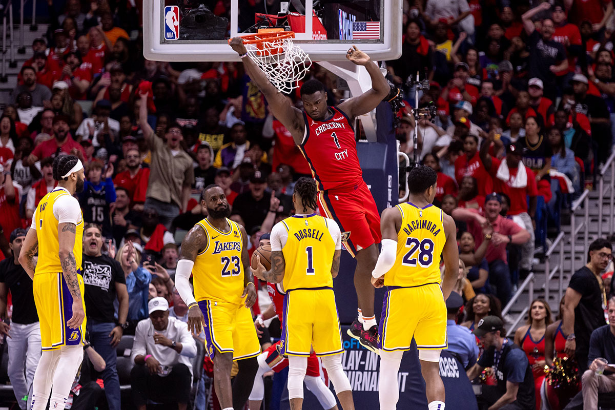 Pelicans forward Zion Williamson (1) dunks the ball against Los Angeles Lakers forward LeBron James (23) and guard D'Angelo Russell (1) during the second half of a play-in game of the 2024 NBA playoffs at Smoothie King Center.