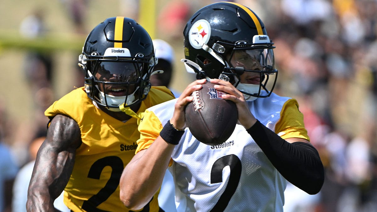 Pittsburgh Steelers quarterback Justin Fields (2) is pressured by safety DeShon Elliott (25) during training camp at Saint Vincent College.