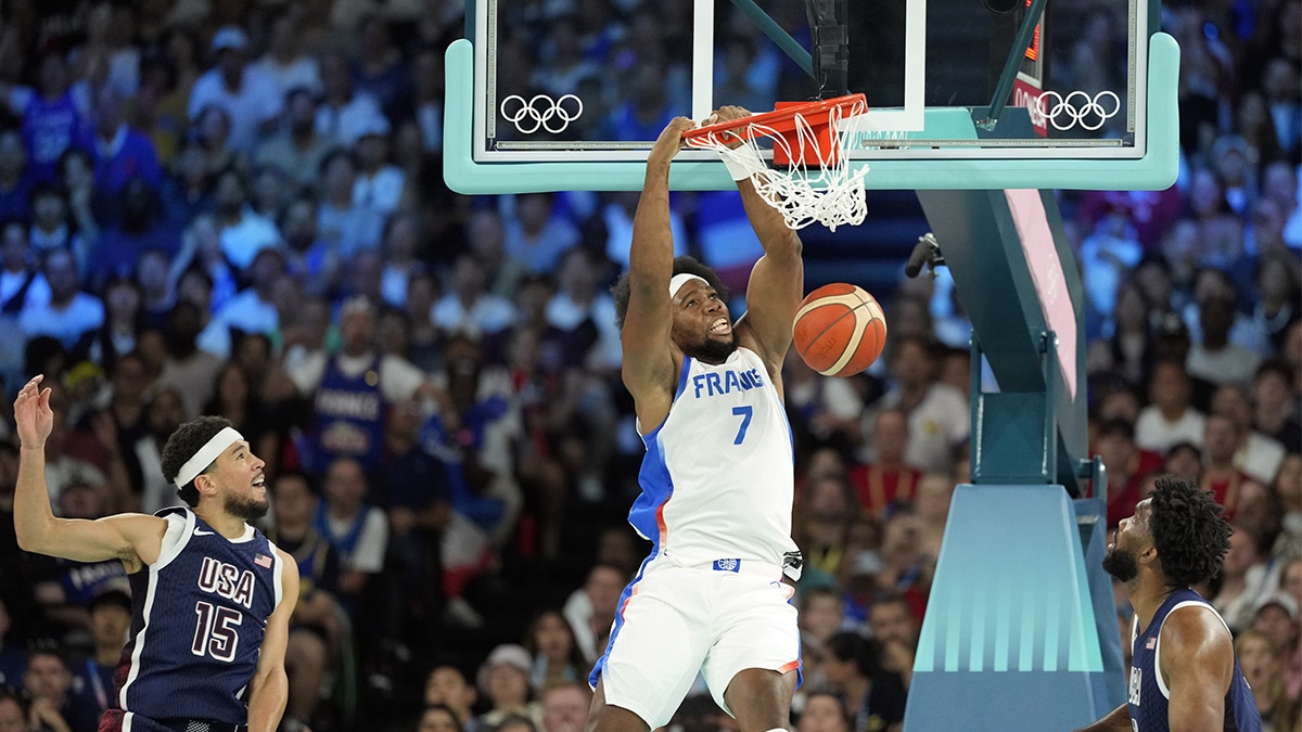 France power forward Guerschon Yabusele (7) dunks against United States guard Devin Booker (15) and centre Joel Embiid (11) in the first quarter in the men's basketball gold medal game during the Paris 2024 Olympic Summer Games at Accor Arena. 