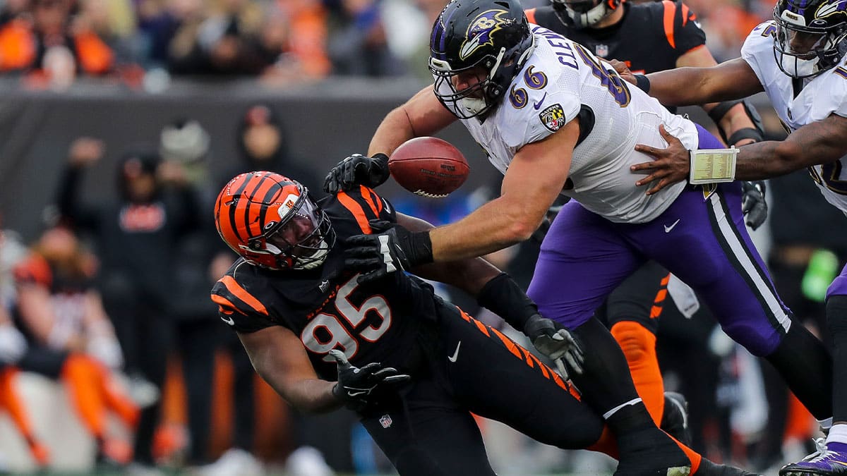 Bengals defensive tackle Zach Carter (95) attempts to catch the tipped ball against Baltimore Ravens guard Ben Cleveland (66) in the second half at Paycor Stadium. 