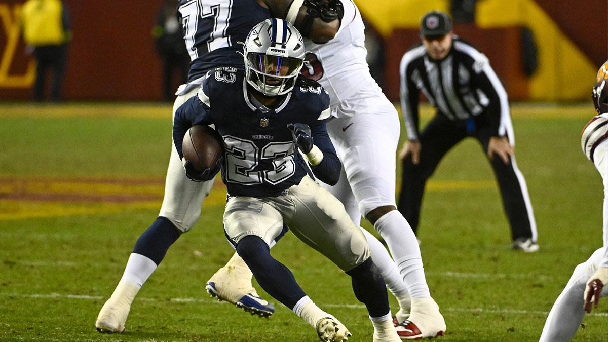 Jan 7, 2024; Landover, Maryland, USA; Dallas Cowboys running back Rico Dowdle (23) carries the ball past Washington Commanders safety Terrell Burgess (32) during the second half at FedExField.