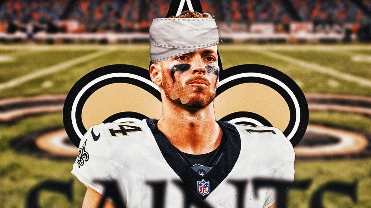 Saints quarterback Jake Haener with a bandage on his face in front of the Saints logo